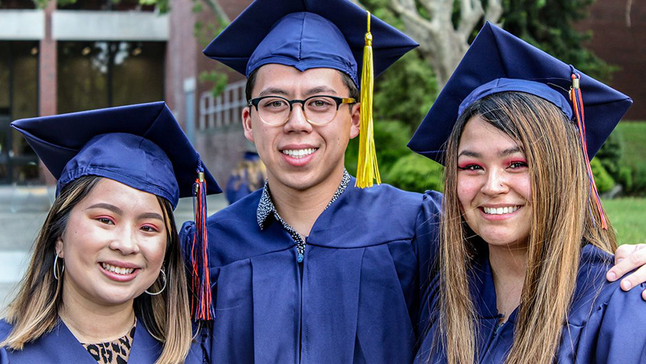 Three CRC students wearing graduation caps and gowns