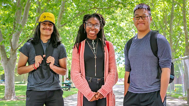Three students on CRC's campus smiling at the camera