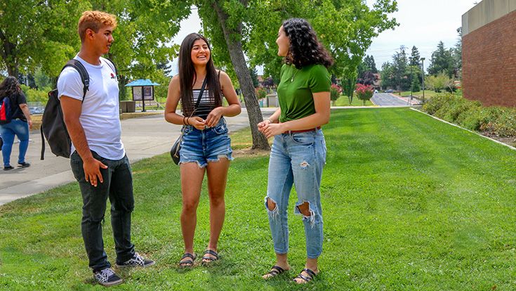 Three students talking outdoors on CRC's campus