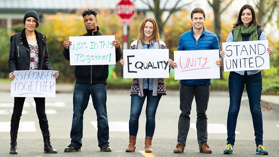 Group of students holding up social justice messages on signs