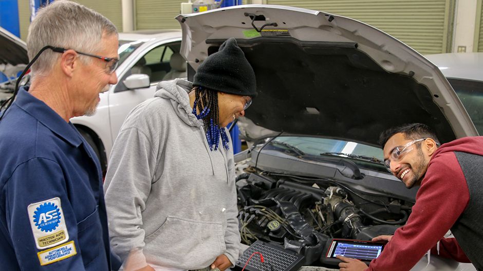 Students working under the hood of a car
