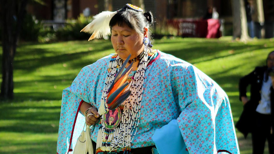 A dancer wearing a blue ceremonial dress during Native American Heritage Week at CRC. Photo by November Rain Erwin.