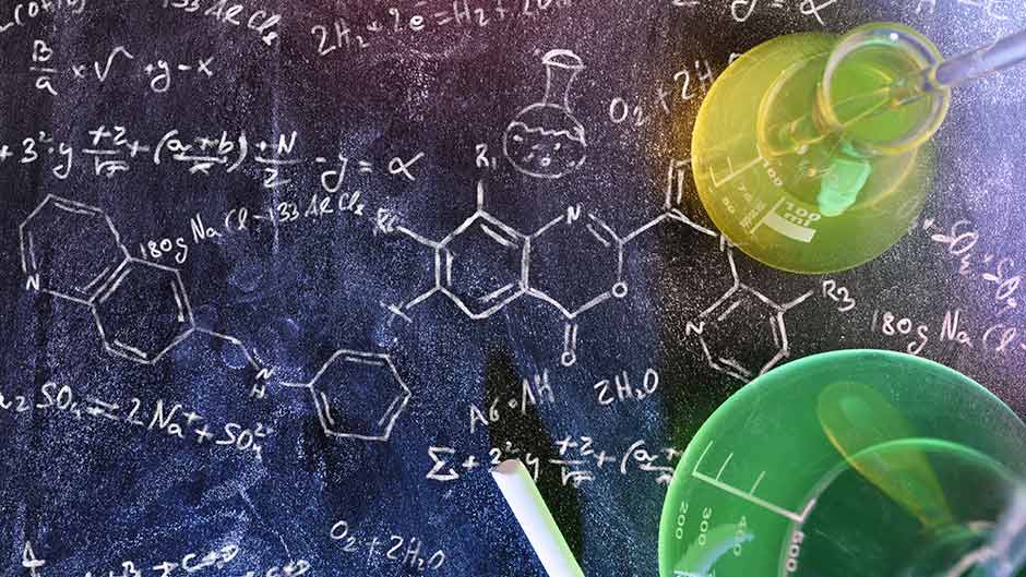 A chalkboard with molecules drawn on it and chemistry beakers
